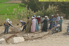 repair workers hauling a stone block