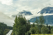 road, clouds caught on mountains